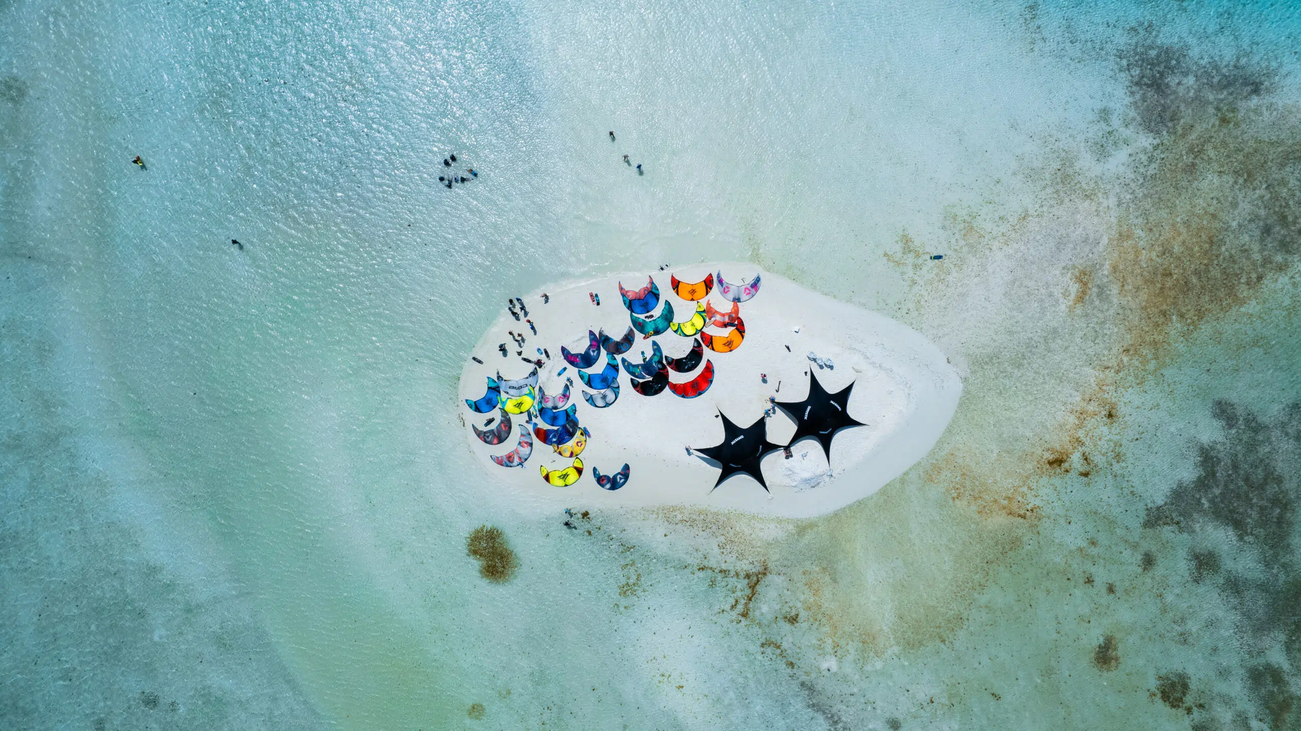 Mała piaszczysta wyspa, turkusowa woda, kolorowe latawce KiteAway - idealny kite camp i wyjazdy kitesurfingowe dla wszystkich.