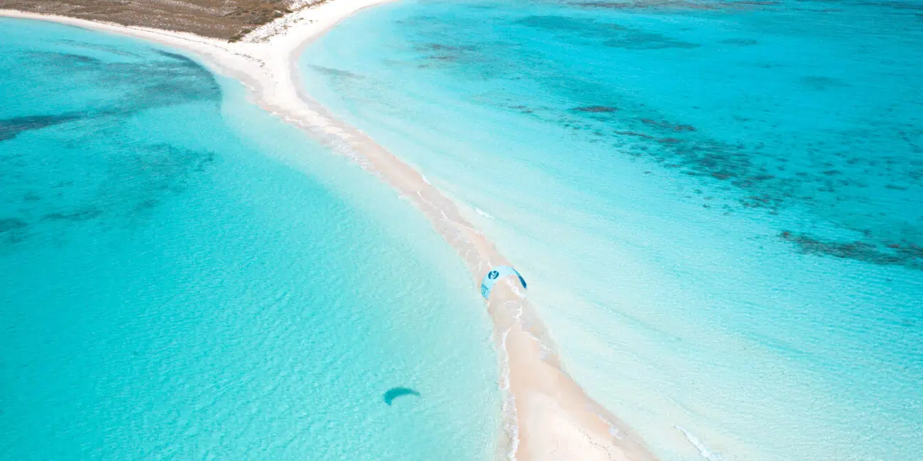 Wyspa z białą mielizną, turkusową wodą i żółtymi namiotami KiteAway - idealny kite trip i wyjazdy kitesurfingowe.