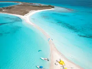 Wyspa z białą mielizną, turkusową wodą i żółtymi namiotami KiteAway - idealny kite trip i wyjazdy kitesurfingowe.