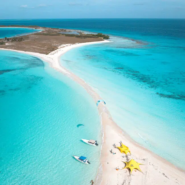 Wyspa z białą mielizną, turkusową wodą i żółtymi namiotami KiteAway - idealny kite trip i wyjazdy kitesurfingowe.