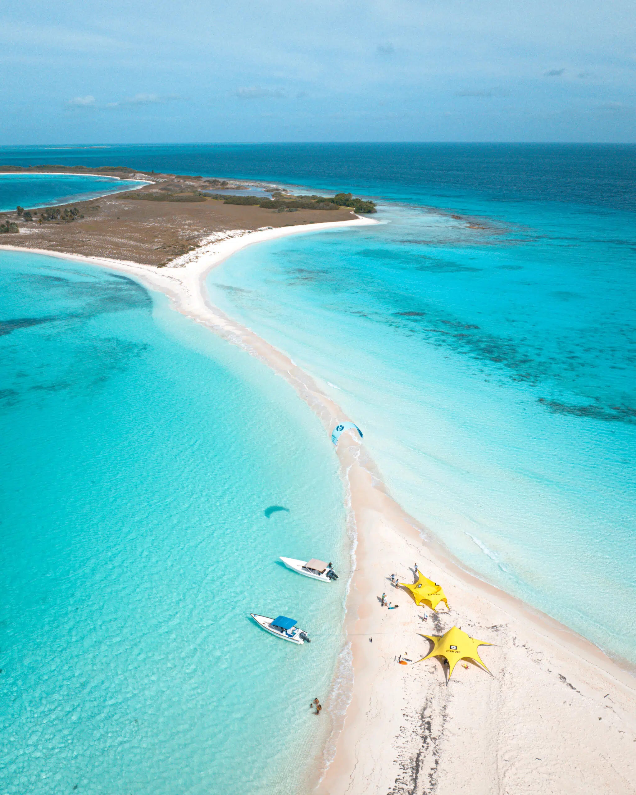 Wyspa z białą mielizną, turkusową wodą i żółtymi namiotami KiteAway - idealny kite trip i wyjazdy kitesurfingowe.