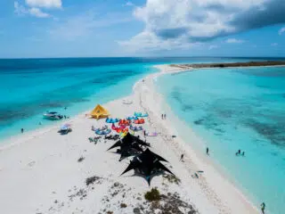 Biała, piaszczysta plaża i turkusowa woda - idealny kite spot KiteAway na wyjazdy kitesurfingowe i kite camp pod chmurkami.