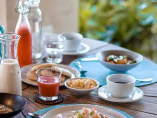 Śniadanie na drewnianym stole w KiteAway kite camp, idealne na wyjazdy kitesurfingowe Rodos-wakacje z kitesurfingiem.