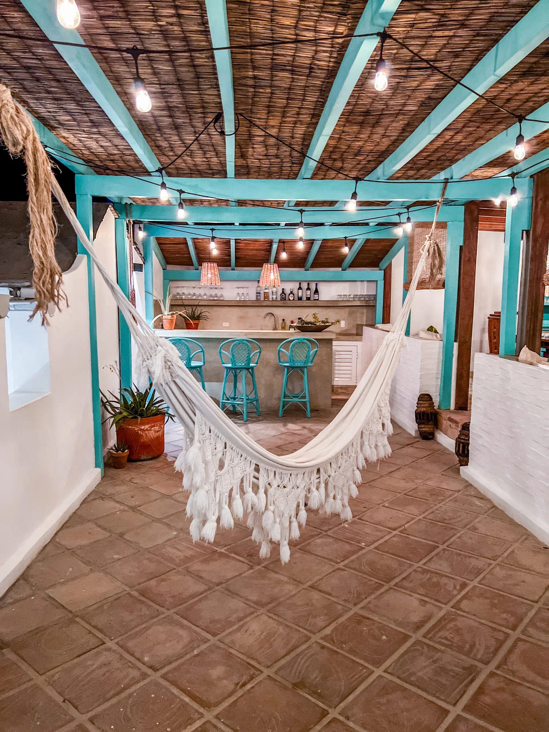 Przytulny taras z białym hamakiem i turkusowymi stolikami, idealny na relaks po kursie kitesurfingu z KiteAway lub kite camp.