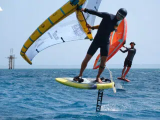 Dwóch kitesurferów na wodolotach ze skrzydłami na błękitnym oceanie podczas wyjazdu KiteAway - idealny kite camp i wakacje z kitesurfingiem.