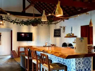 Rustykalna kuchnia i bar z drewnem, hamakiem i roślinami-idealne miejsce na relaks po wyjeździe kitesurfingowym z KiteAway.