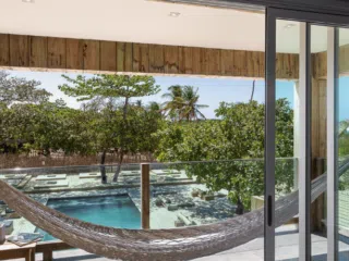 Biały hamak na balkonie z widokiem na basen i morze - relaks po wyjeździe kitesurfingowym z KiteAway lub kite camp.