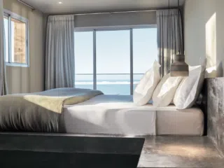 Nowoczesna sypialnia z widokiem na morze - idealna na relaks po kite camp KiteAway; świetne miejsce na wakacje z kitesurfingiem.