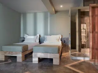 Nowoczesny pokój z dwoma łóżkami - idealny na wyjazdy kitesurfingowe KiteAway; minimalistyczny styl, łazienka obok.