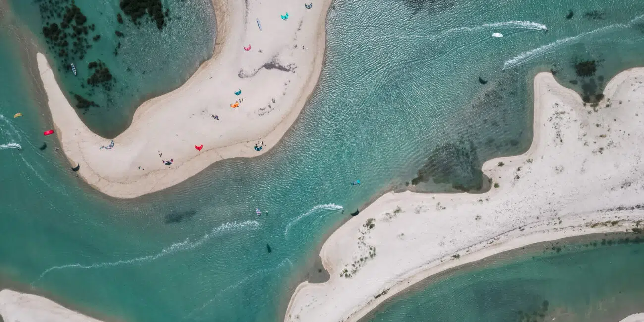 Widok z lotu ptaka na kręte piaszczyste łachy i turkusową wodę - idealne miejsce na wyjazdy kitesurfingowe z KiteAway.
