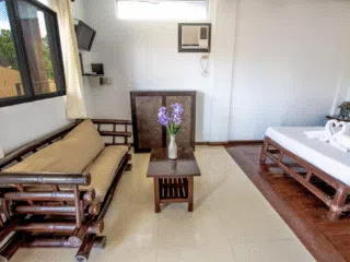 Przytulny pokój po kite camp KiteAway: bambusowa sofa, stolik, łóżko z łabędziami z ręczników, idealny na relaks po wyjazdach kitesurfingowych.