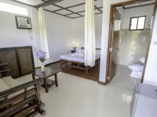 Jasny pokój hotelowy idealny na wyjazdy kitesurfingowe z KiteAway: podwójne łóżko, bambusowe meble, mini lodówka.