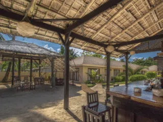 Bar i strefa relaksu z hamakiem na plaży - idealne miejsce na wyjazdy kitesurfingowe KiteAway, kolorowe latawce nad palmami.