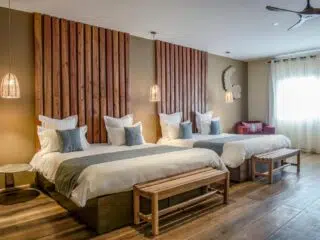 Nowoczesny pokój hotelowy na wyjazdy kitesurfingowe: dwa łóżka, wygodne ławki, duże okno, idealny na kite camp z KiteAway.