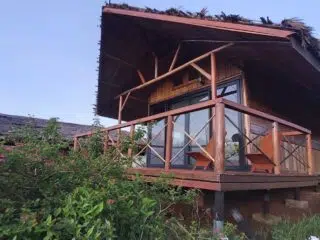 Przytulny domek z werandą wśród zieleni, idealny na relaks po kite campie lub szkoleniu kite z KiteAway.