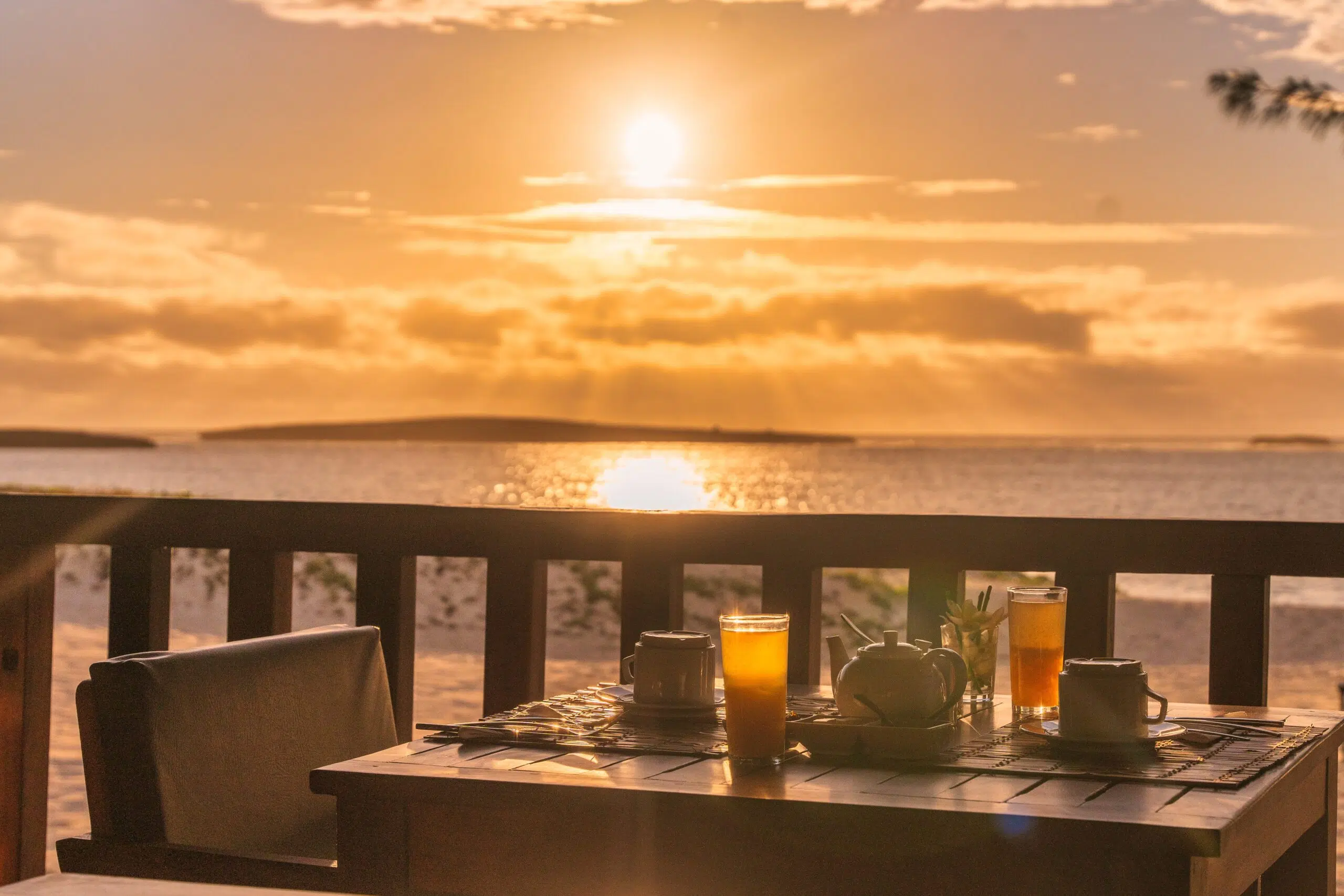 Stolik na dwie osoby z herbatą i sokiem z widokiem na spokojne morze - idealny na planowanie wyjazdu na kite camp z KiteAway.