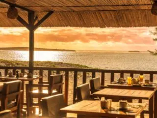 Restauracja na plaży z widokiem na kite spot i zachód słońca, idealne miejsce na relaks po wyjazdach kitesurfingowych z KiteAway.