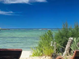 Dwa leżaki na piaszczystej plaży z widokiem na turkusowe morze - idealne miejsce na relaks po kursie kitesurfingu KiteAway.