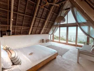 Przytulna sypialnia z dużymi oknami na oceanie, idealna na relaks po kursie kitesurfingu z KiteAway lub intensywnym obozie kitesurfingowym.