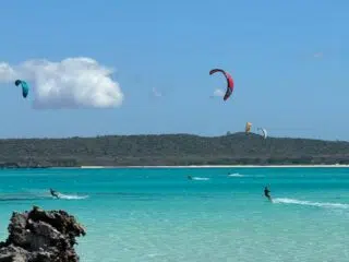 Turkusowe morze, kolorowe latawce i kitesurferzy na tle błękitnego nieba - idealny spot na wyjazdy kitesurfingowe z KiteAway.