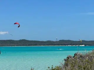 Kolorowe latawce kitesurferów nad turkusową wodą - idealny kite camp, wyjazdy kitesurfingowe z KiteAway, piaszczysta plaża, natura.