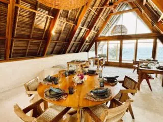 Przytulna, rustykalna jadalnia z widokiem na wodę, idealna na wieczory po kite campie KiteAway i wyjazdy kitesurfingowe.