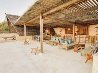 Klimatyczny beach bar z drewnem i strzechą na kite campie KiteAway - idealny relaks po wyjazdach kitesurfingowych.