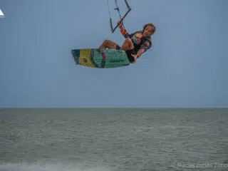 Kitesurfer wykonuje skok nad spokojnym morzem podczas kite tripu z KiteAway. Idealne wakacje z kitesurfingiem. Fot. Maciej Zimas Zimowski.