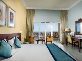 Jasny pokój hotelowy z widokiem na morze, idealny na wakacje z kitesurfingiem lub po kursie kitesurfingu z KiteAway.