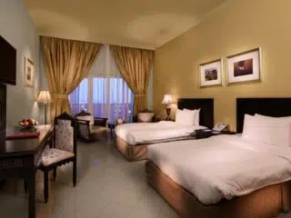 Pokój hotelowy na kite camp KiteAway: dwa łóżka, TV, biurko; idealny na wyjazdy kitesurfingowe lub wakacje z kitesurfingiem.