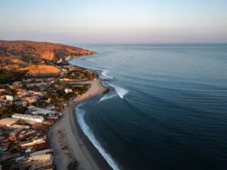 Wybrzeże z piaszczystą plażą, łagodnymi falami i łodziami - idealne miejsce na wyjazdy kitesurfingowe lub kurs kitesurfingu.
