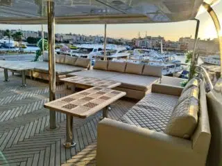 Przestronny salon na jachcie po kite tripie, wygodne siedziska i widok na marinę - relaks podczas wyjazdu kitesurfingowego.